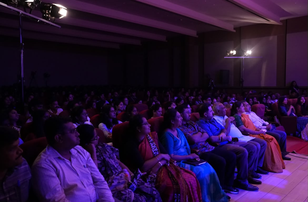 Packed auditorium audience watching a performance